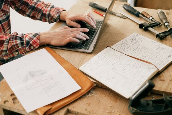 Professional handyman working on project planning with tools and blueprints, demonstrating careful attention to detail and expertise